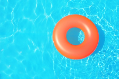 Photo of Inflatable ring floating in swimming pool on sunny day, top view with space for text