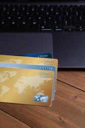 Photo of Credit cards and laptop on wooden table