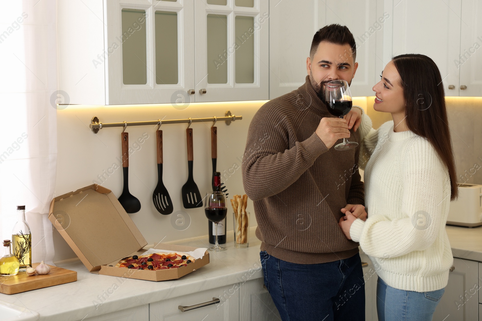 Photo of Happy young couple spending time together in kitchen