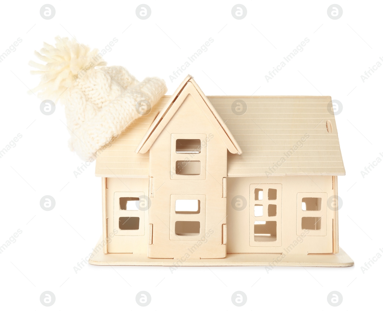 Photo of House model with knitted hat on roof against white background. Heating concept