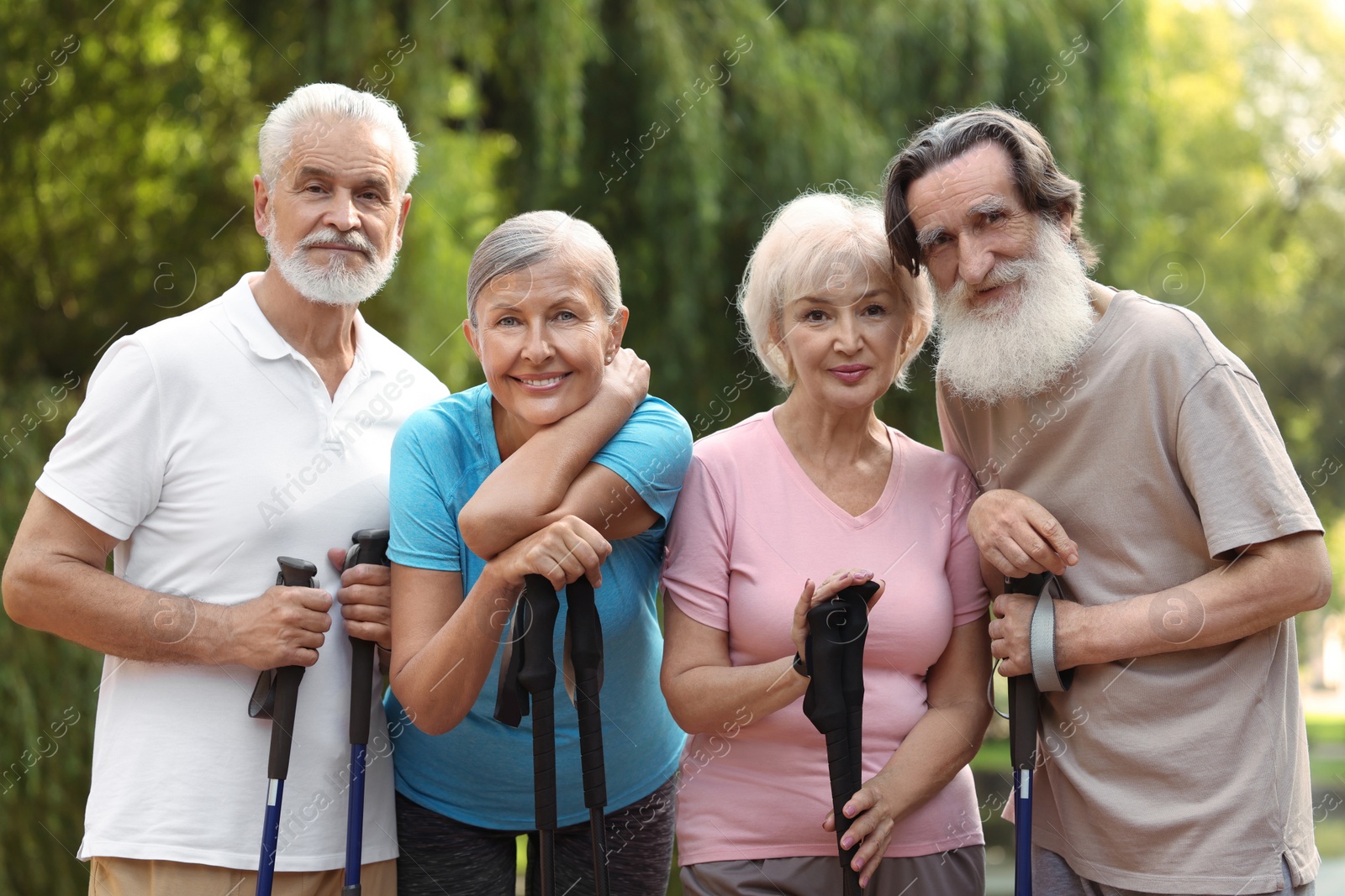 Photo of Group of senior people with Nordic walking poles outdoors