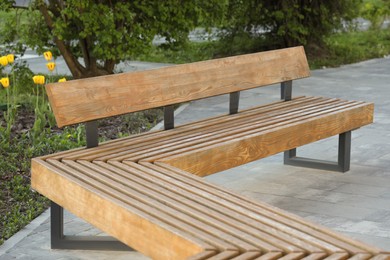 Wooden bench near green area in city park