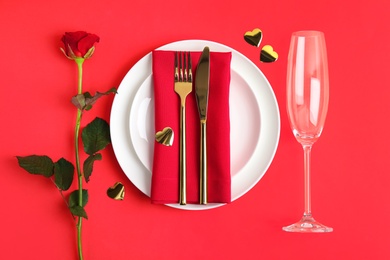 Photo of Beautiful table setting for romantic dinner on red background, flat lay. Valentine's day celebration