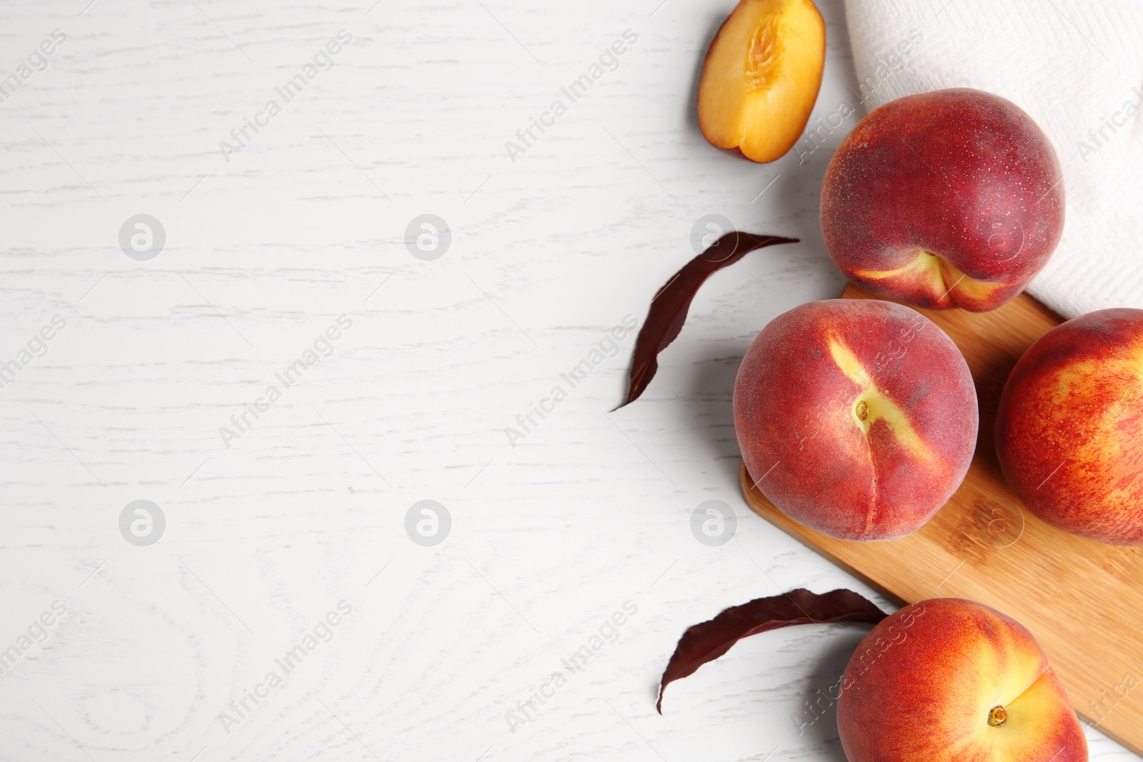 Photo of Flat lay composition with fresh peaches on white wooden background, space for text