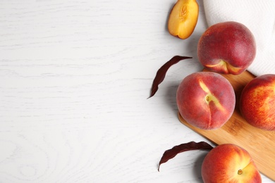 Photo of Flat lay composition with fresh peaches on white wooden background, space for text