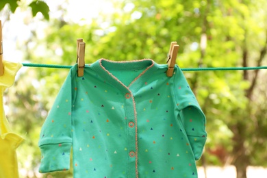 Photo of Laundry line with child's clothes outdoors on sunny day