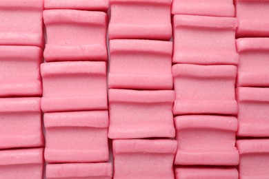 Photo of Tasty pink chewing gums as background, top view