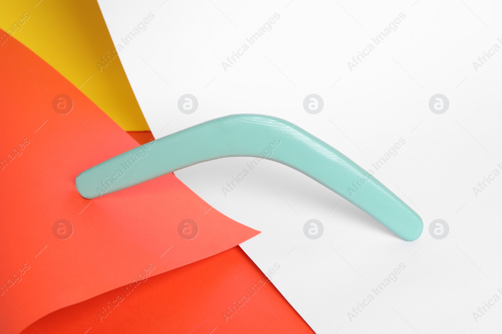 Photo of Turquoise boomerang on color background. Outdoor activity