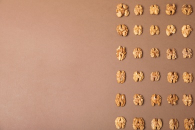 Tasty walnuts on color background, flat lay with space for text