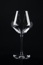 Photo of New empty wine glass on black background