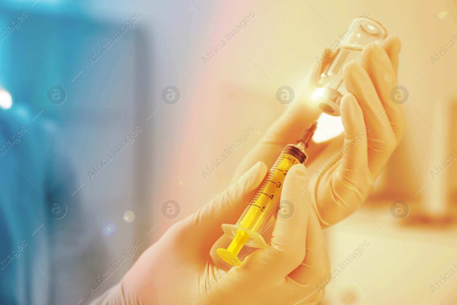 Image of Doctor filling syringe with medication from vial indoors, closeup