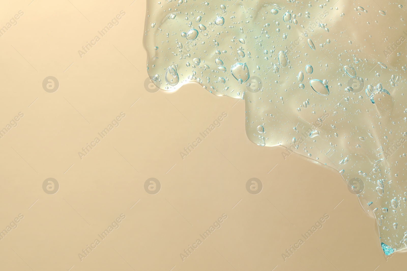 Photo of Transparent cleansing gel on beige background, top view with space for text. Cosmetic product