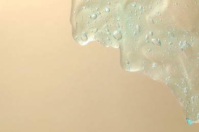 Photo of Transparent cleansing gel on beige background, top view with space for text. Cosmetic product