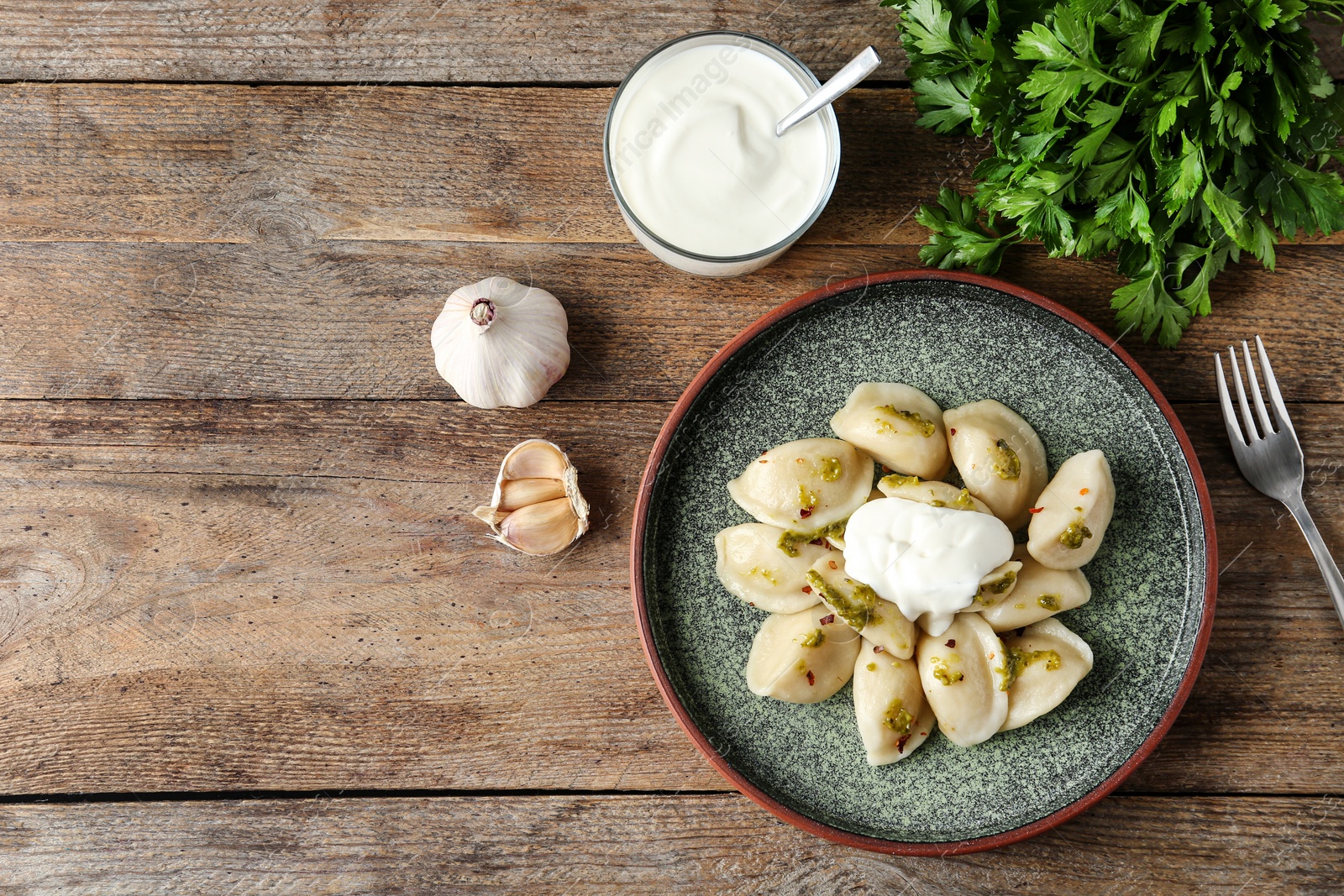 Photo of Delicious cooked dumplings served on wooden table, flat lay. Space for text