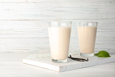 Glasses with vanilla milk shakes on table