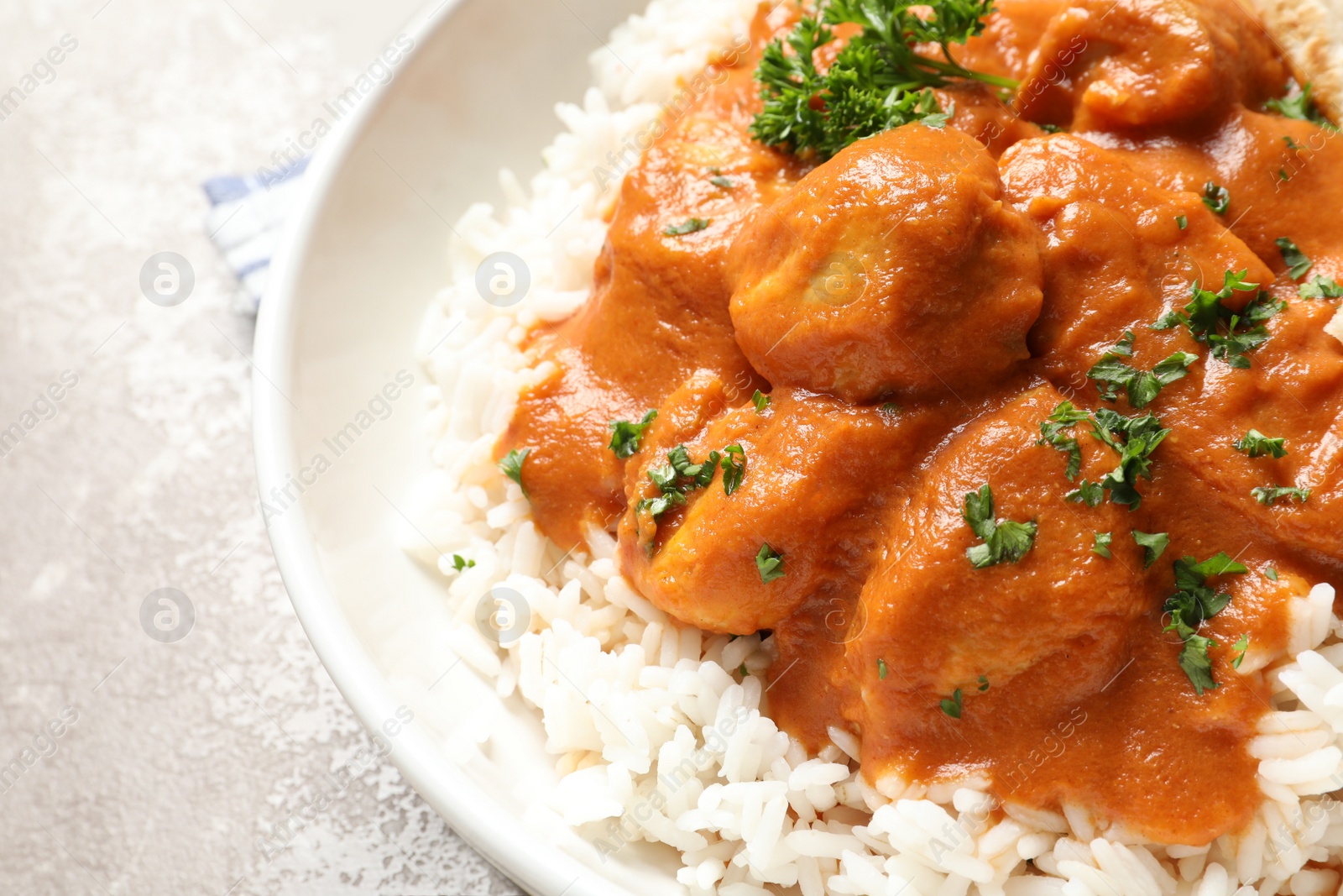 Photo of Delicious butter chicken with rice in bowl on table, closeup