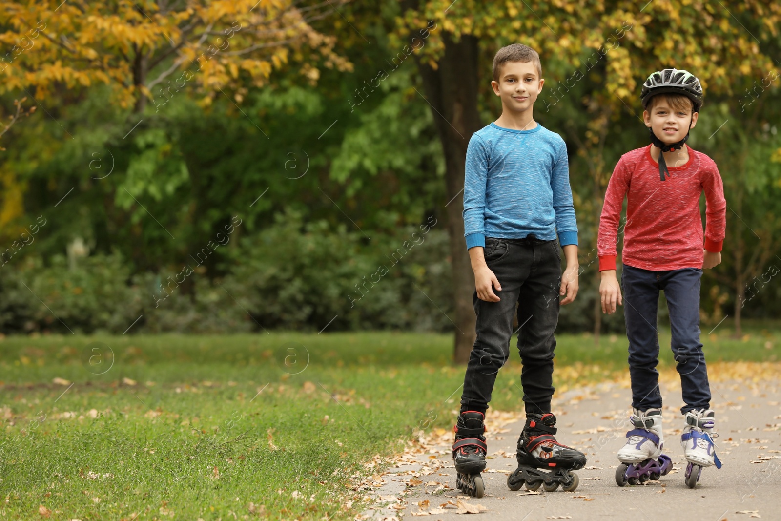 Photo of Happy children roller skating in autumn park. Space for text