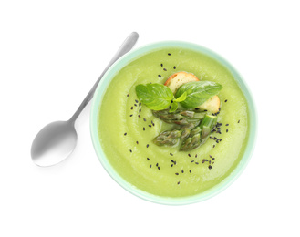 Delicious asparagus soup with basil and sesame seeds isolated on white, top view