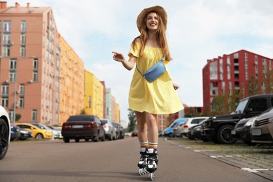 Photo of Beautiful young woman with roller skates having fun outdoors