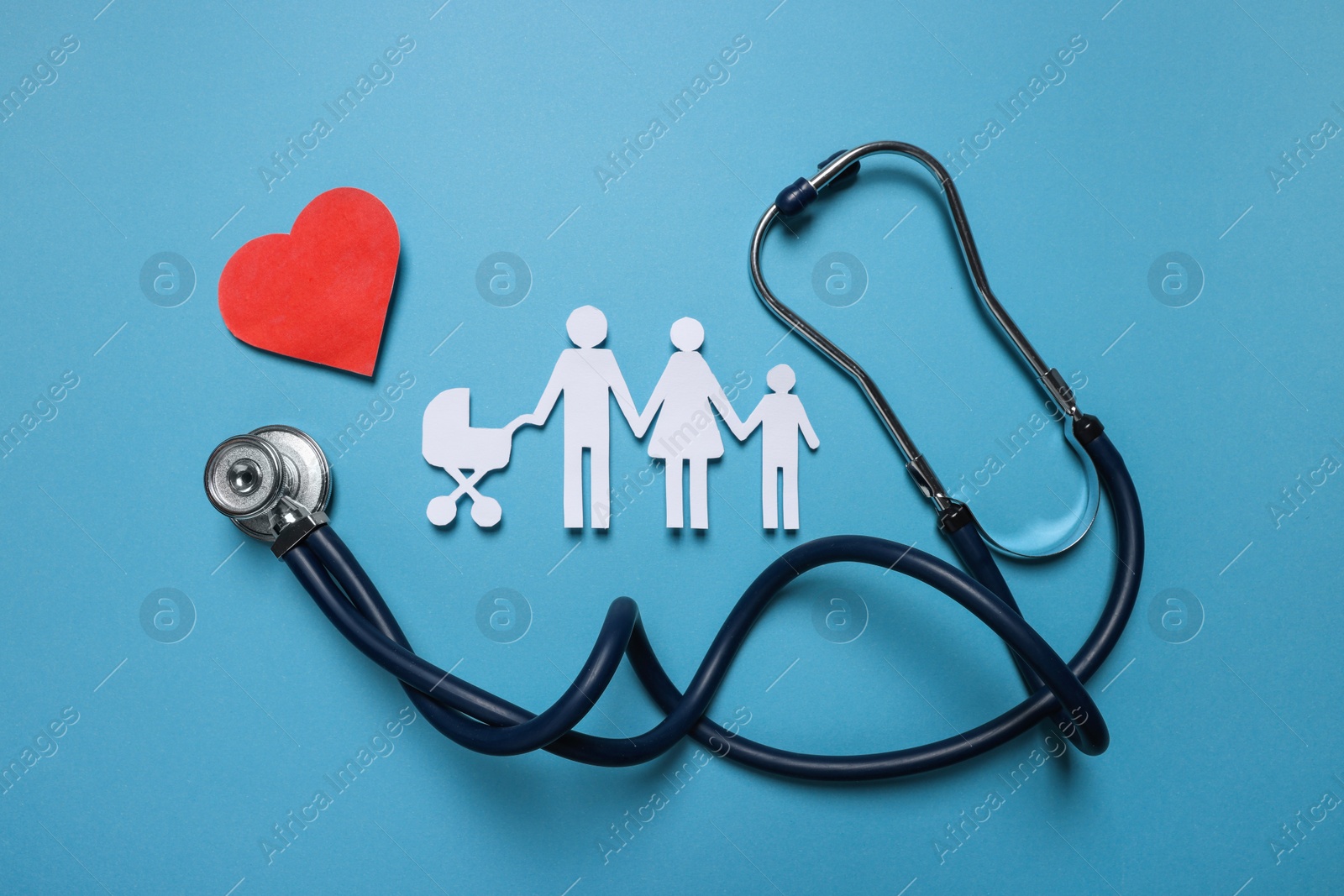 Photo of Paper family figures, red heart and stethoscope on light blue background, flat lay. Insurance concept