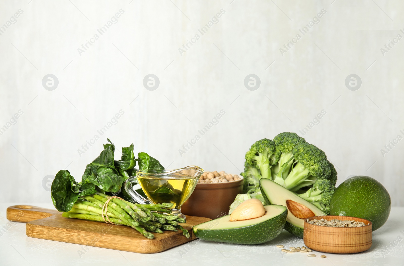 Photo of Different products rich in vitamin E on white table. Space for text