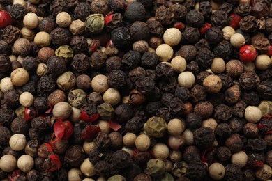 Photo of Aromatic spices. Different peppers as background, top view