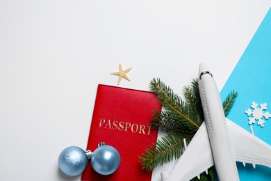 Photo of Flat lay composition with Christmas decorations and passport on color background, space for text. Winter vacation