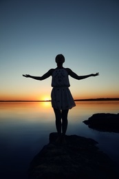 Photo of Woman near river on sunset. Healing concept
