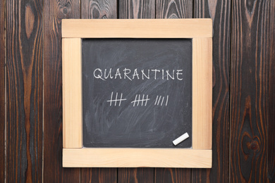 Blackboard with chalk on wooden background, top view. Counting days of quarantine during coronavirus outbreak 
