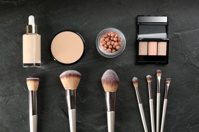 Photo of Flat lay composition with makeup brushes on black stone table