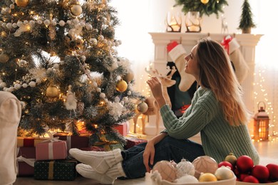 Beautiful woman decorating Christmas tree at home
