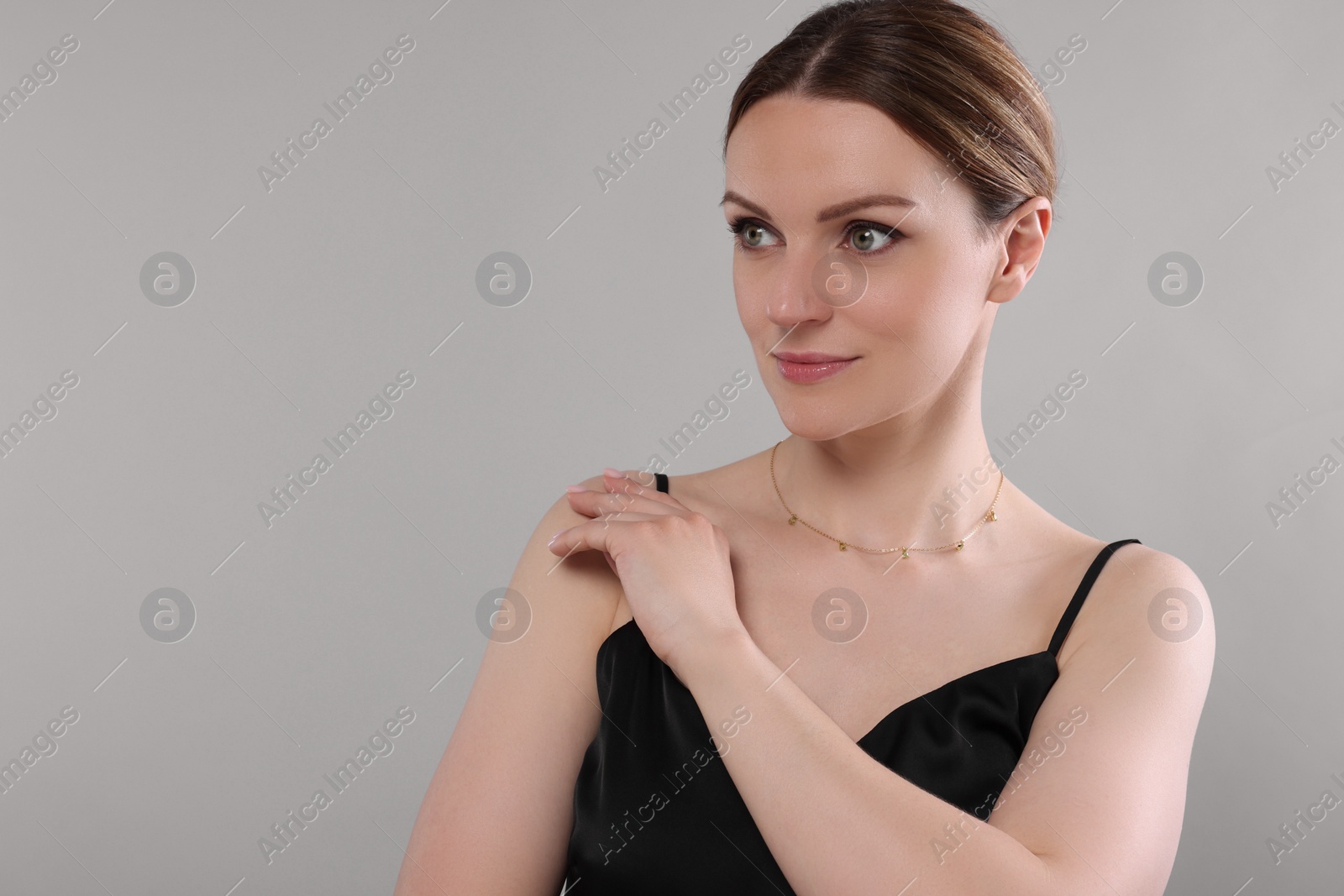 Photo of Beautiful woman with elegant necklace on light grey background. Space for text