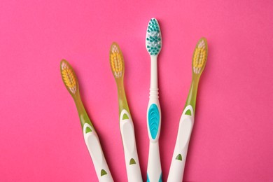Photo of New toothbrushes on pink background, flat lay