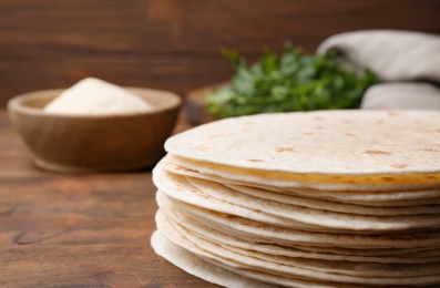 Photo of Corn tortillas on wooden table, closeup with space for text. Unleavened bread