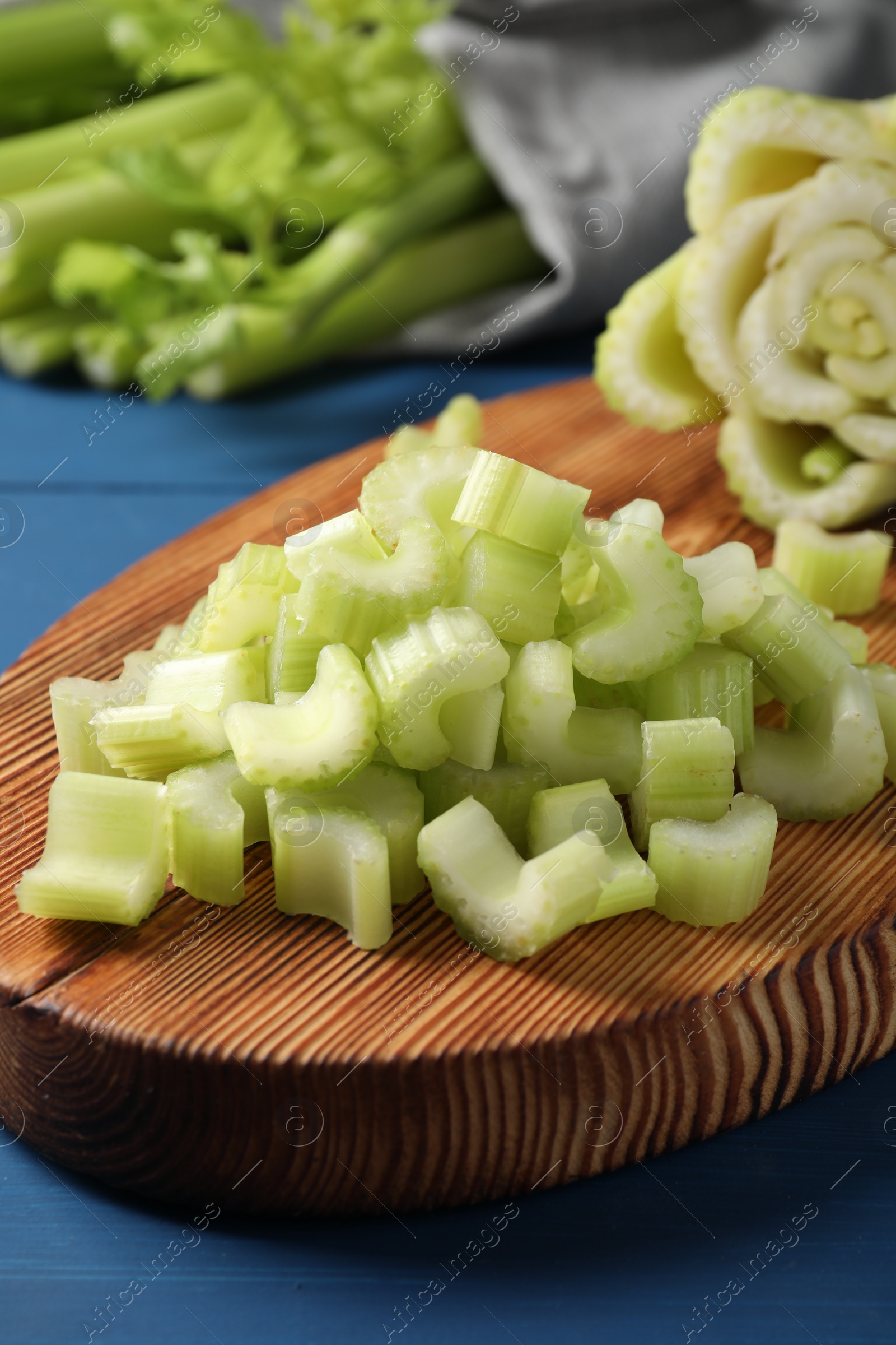 Photo of Fresh cut celery on blue wooden table, closeup