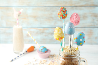 Photo of Egg shaped cake pops on light table, space for text. Easter celebration