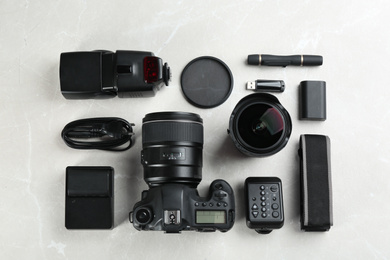 Photo of Flat lay composition with equipment for professional photographer on grey marble table