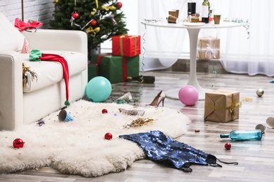 Photo of Messy living room interior with Christmas tree. Chaos after party