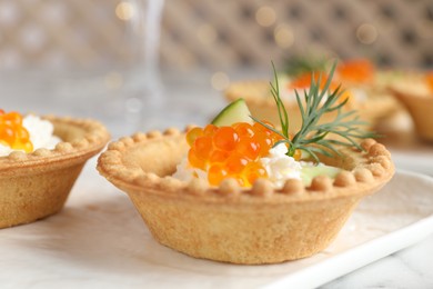 Delicious canapes with red caviar on table, closeup