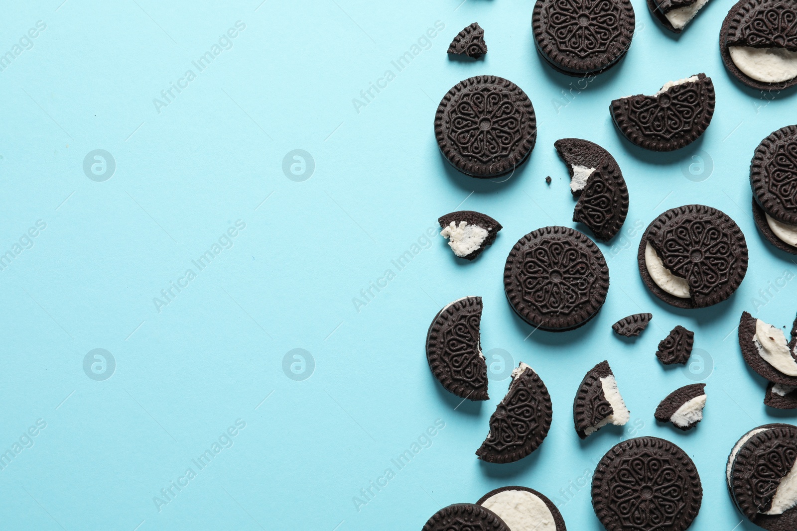 Photo of Tasty chocolate cookies with cream on color background, flat lay. Space for text