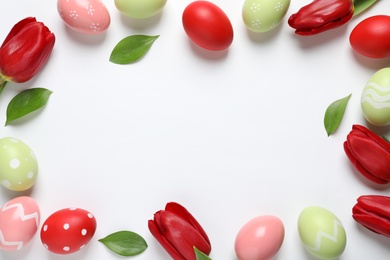 Flat lay composition of painted Easter eggs on white background, space for text