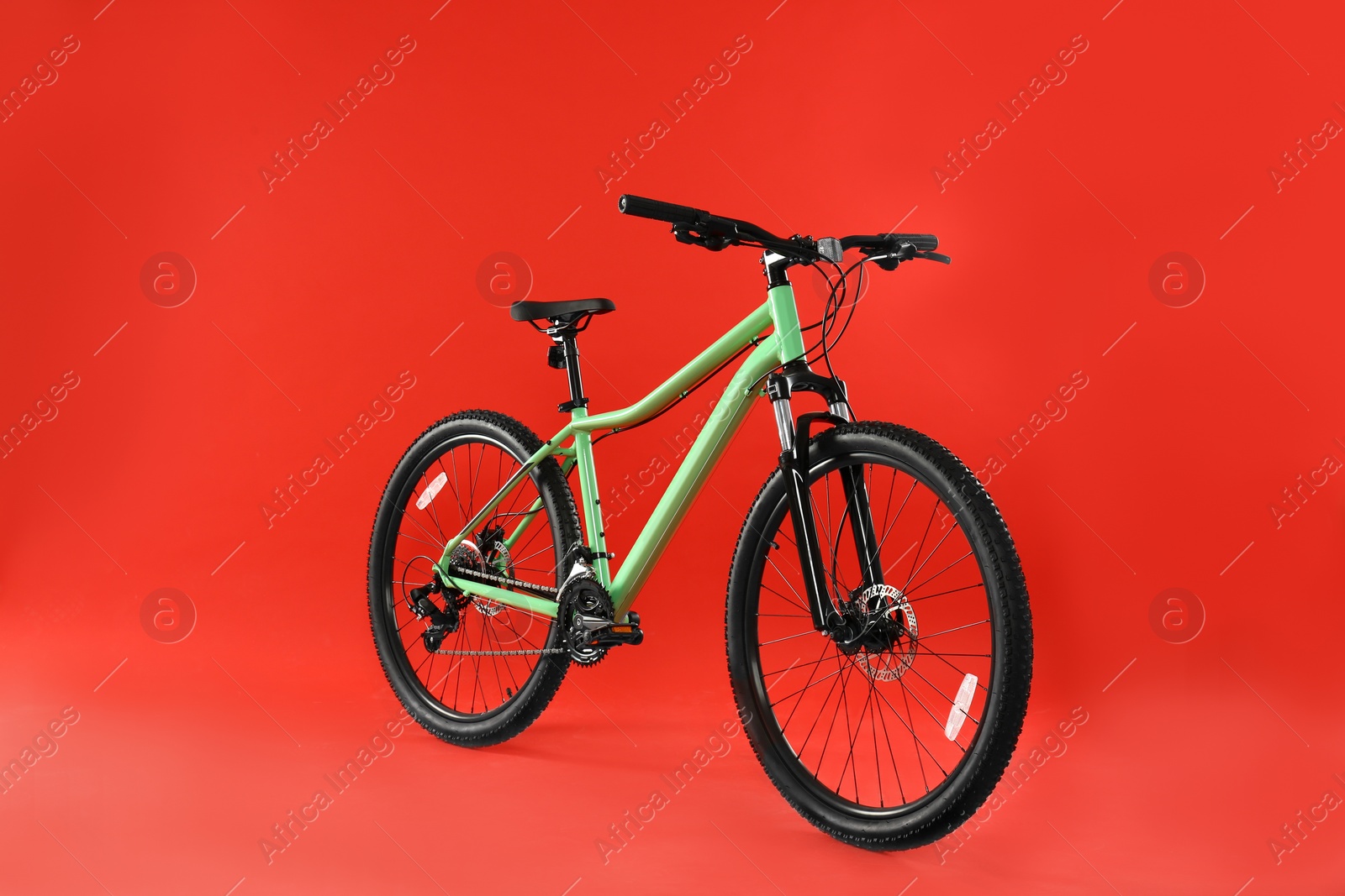 Photo of Modern bicycle on red background. Healthy lifestyle
