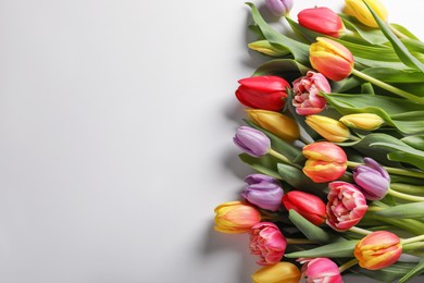 Photo of Beautiful tulips on light grey background, flat lay. Space for text