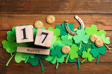 Flat lay composition with horseshoe and block calendar on wooden background. St. Patrick's Day celebration