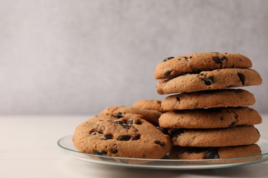 Delicious chocolate chip cookies on white marble table, closeup. Space for text