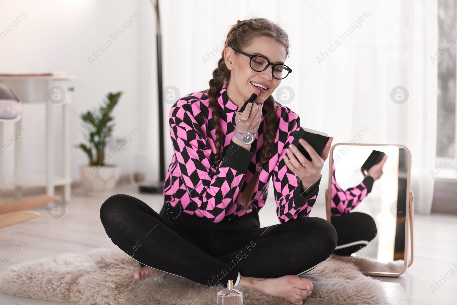 Photo of Portrait of beautiful woman applying makeup indoors