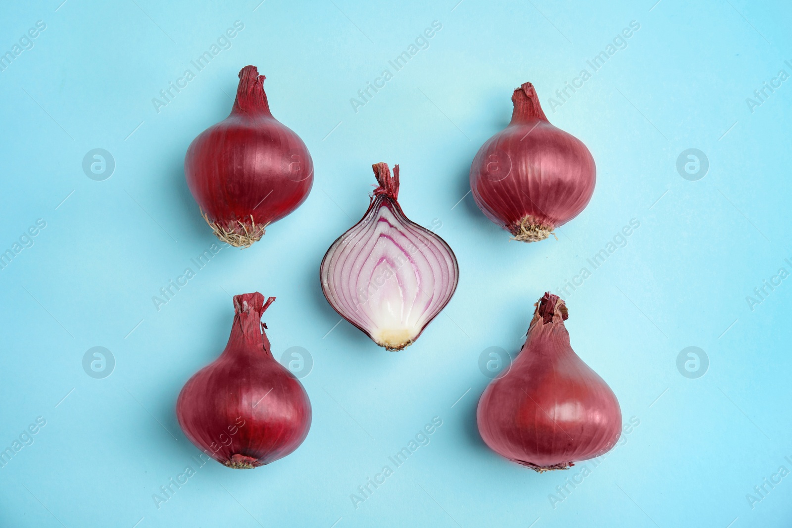 Photo of Beautiful composition with ripe red onions on color background