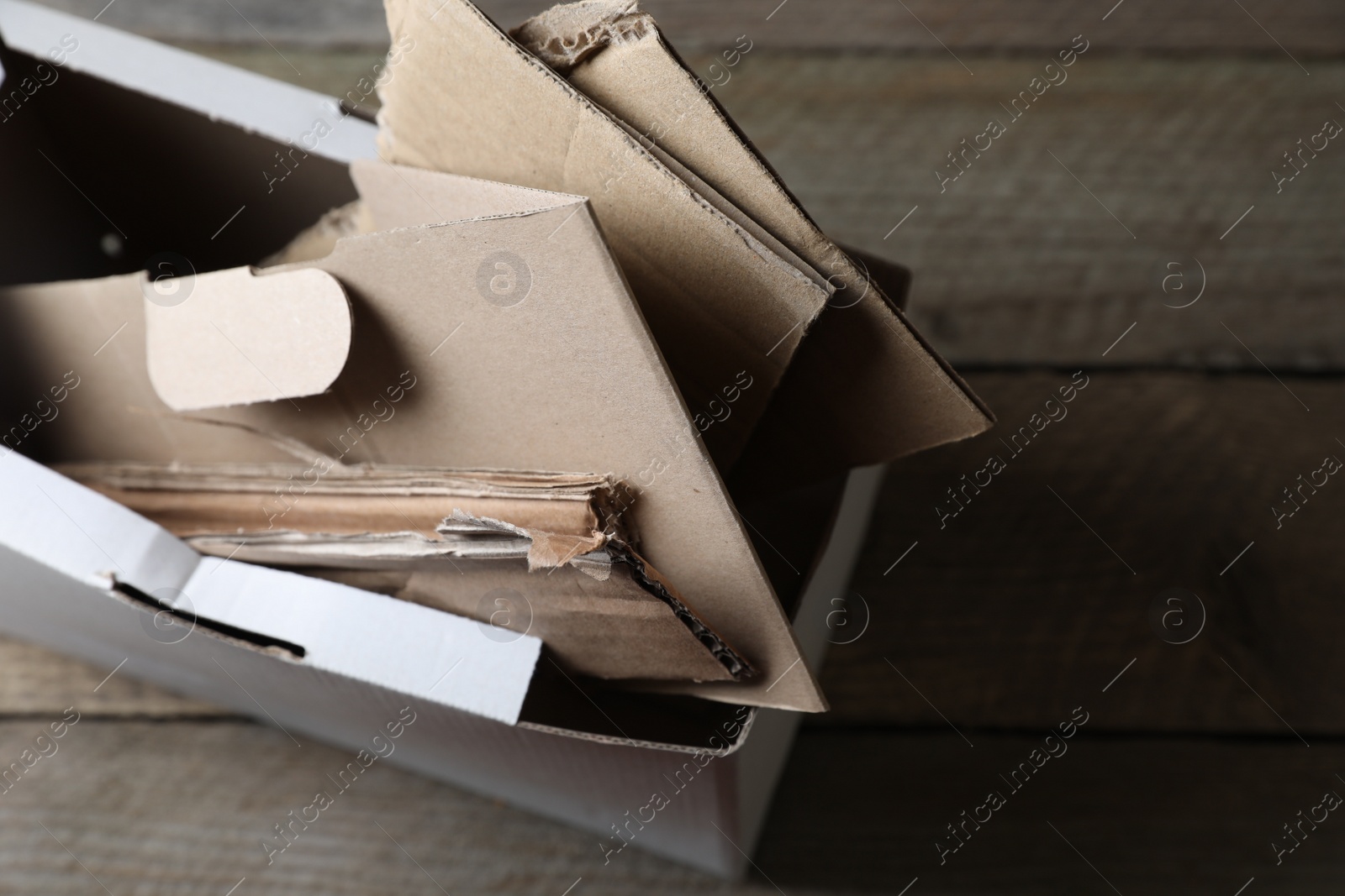 Photo of Box of waste paper on wooden table, view from above. Space for text