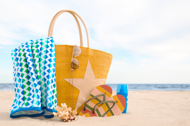 Photo of Different stylish beach objects and coral on sand near sea