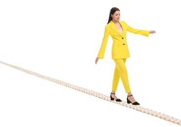 Image of Businesswoman walking rope against white background. Risk or balance concept